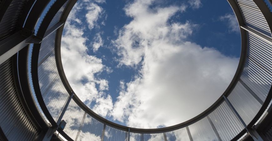 blue sky with fluffy clouds through round window